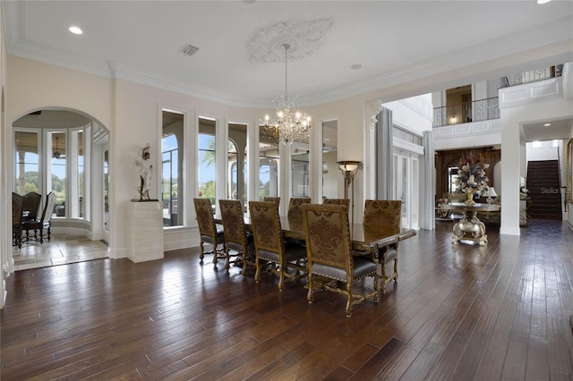 dining area with ornamental molding, an inviting chandelier, and dark hardwood / wood-style flooring