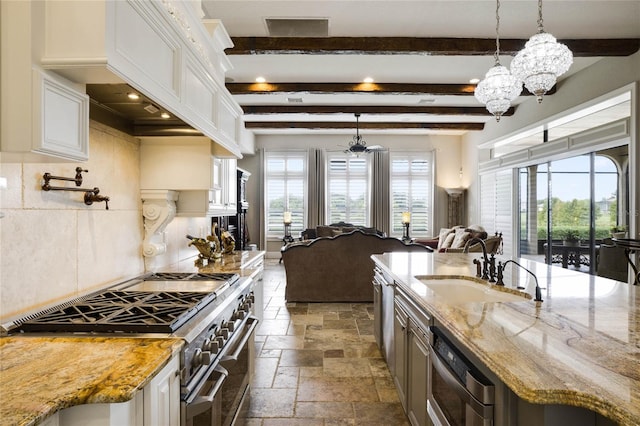 kitchen featuring light stone counters, stainless steel appliances, white cabinets, hanging light fixtures, and backsplash