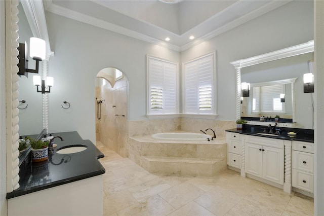 bathroom featuring a relaxing tiled tub, vanity, and crown molding