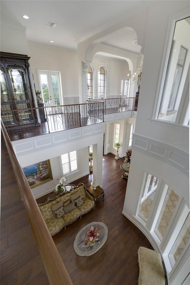 living room with a notable chandelier, crown molding, french doors, and dark hardwood / wood-style flooring