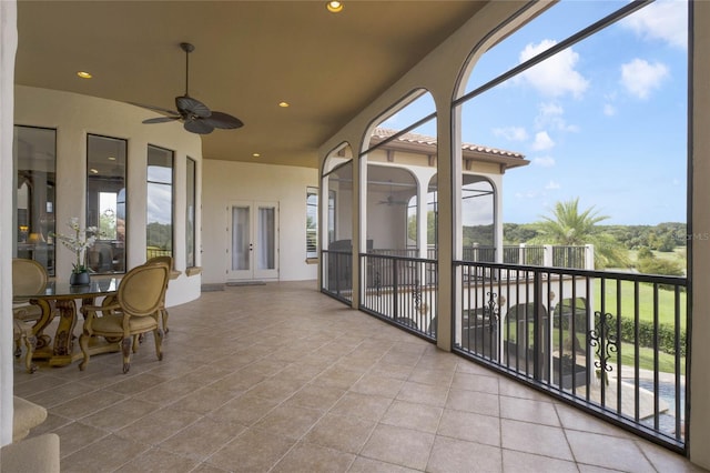 sunroom / solarium with ceiling fan, plenty of natural light, and french doors