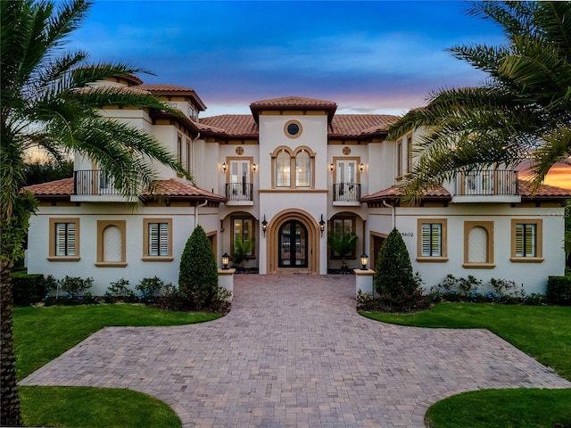 mediterranean / spanish house featuring a yard and a balcony