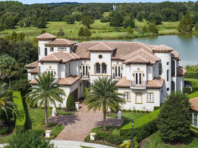 view of front of property with a water view, a front yard, and a balcony