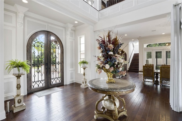 foyer entrance featuring crown molding, dark wood-type flooring, and french doors