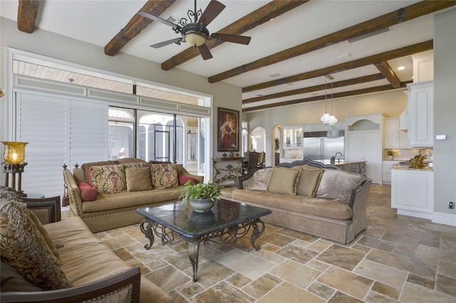 living room with beam ceiling, sink, and ceiling fan