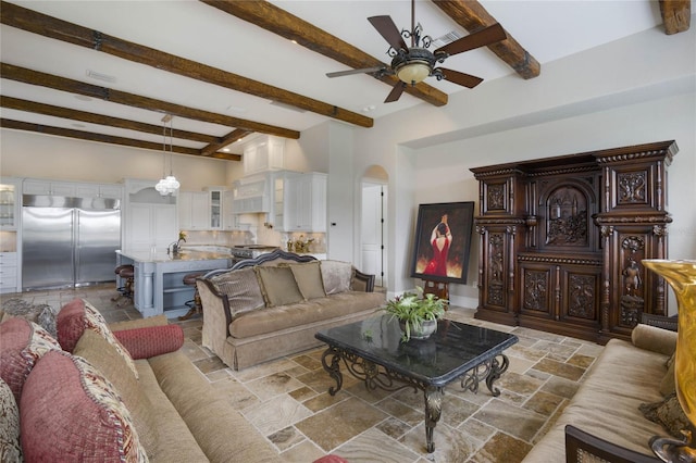 living room featuring beamed ceiling and ceiling fan