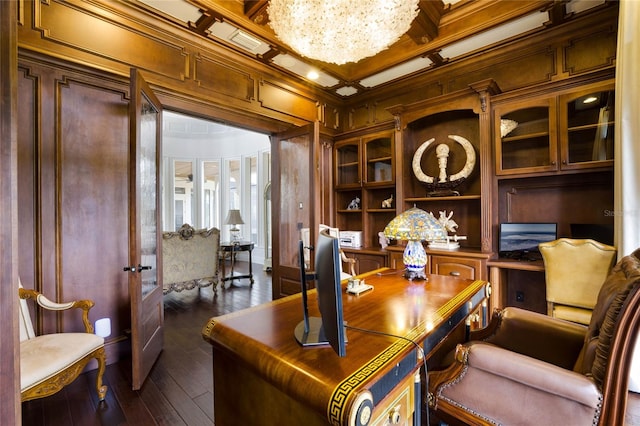 office area featuring wood walls, ornamental molding, a chandelier, coffered ceiling, and dark hardwood / wood-style flooring