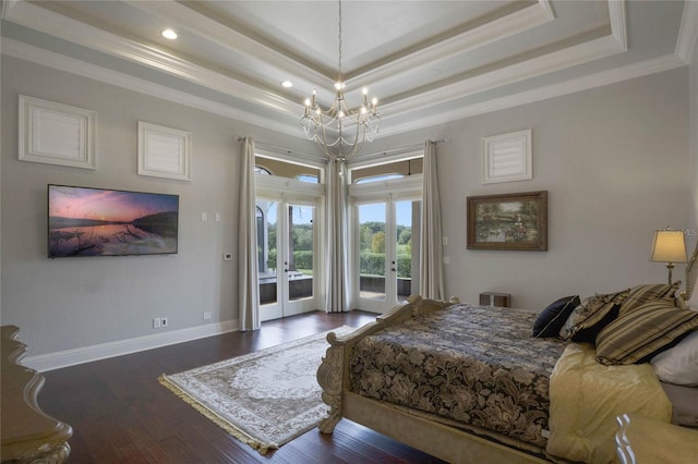 bedroom featuring a raised ceiling, ornamental molding, dark wood-type flooring, a chandelier, and access to exterior