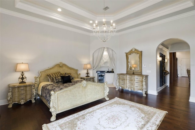 bedroom featuring ornamental molding, an inviting chandelier, a raised ceiling, and dark wood-type flooring