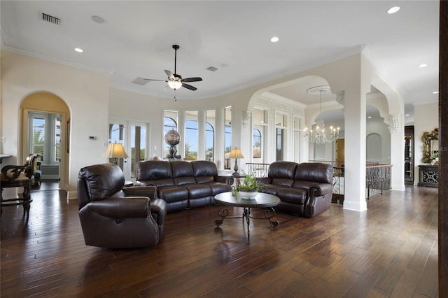 living room featuring dark wood-type flooring, ceiling fan with notable chandelier, crown molding, and a healthy amount of sunlight