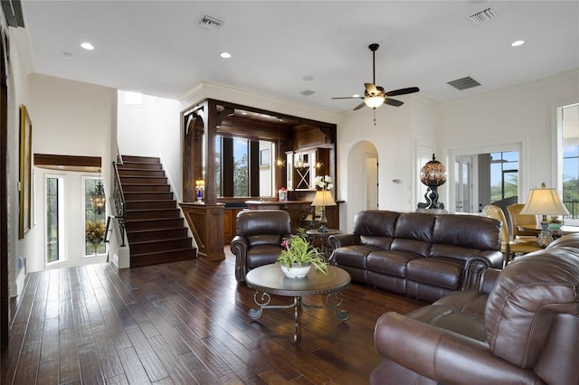 living room featuring a healthy amount of sunlight, ceiling fan, and dark wood-type flooring