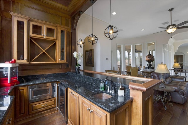 kitchen with pendant lighting, beverage cooler, stainless steel microwave, sink, and dark hardwood / wood-style floors