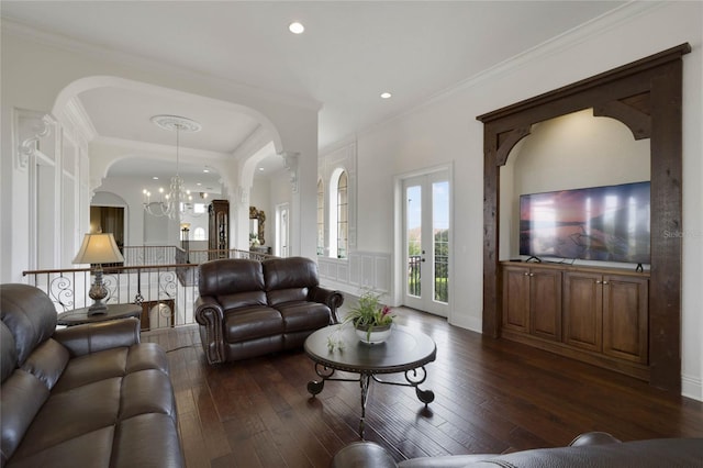 living room featuring dark hardwood / wood-style floors, crown molding, french doors, and a chandelier