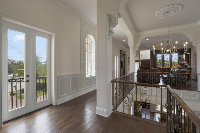 interior space featuring hardwood / wood-style flooring, crown molding, french doors, and an inviting chandelier