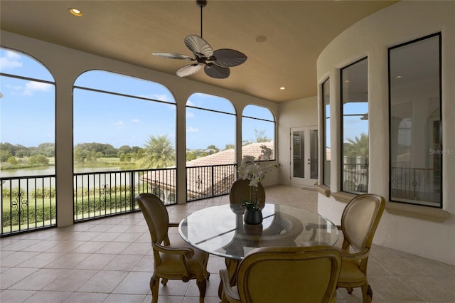 sunroom / solarium with a water view and ceiling fan