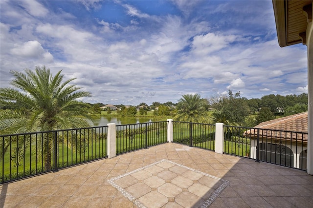 view of patio featuring a water view and a balcony