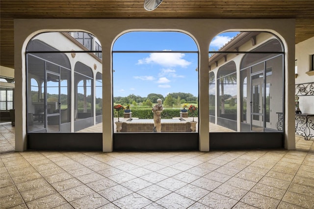 unfurnished sunroom with wood ceiling