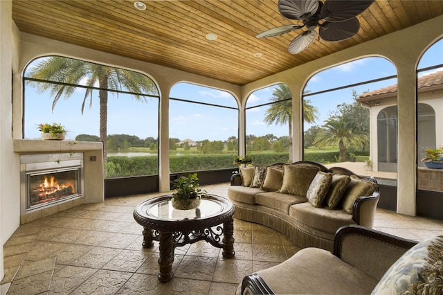 sunroom featuring ceiling fan, a wealth of natural light, and wooden ceiling