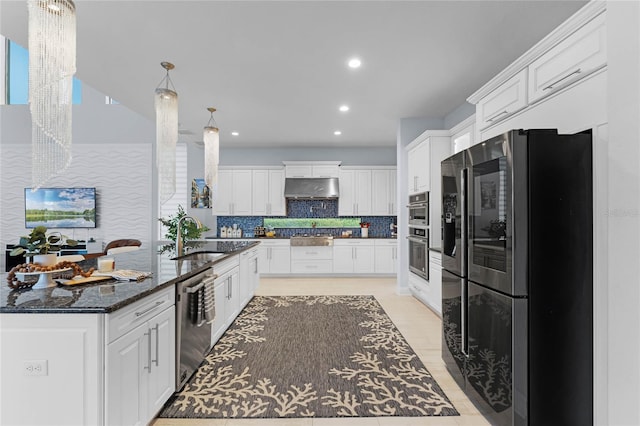 kitchen with decorative backsplash, stainless steel appliances, dark stone countertops, sink, and white cabinets