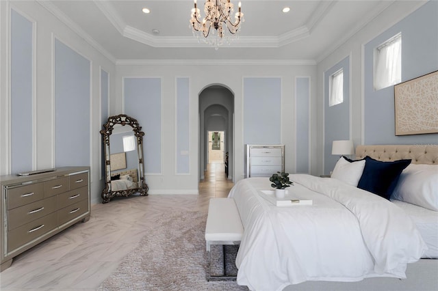 bedroom featuring a tray ceiling, ornamental molding, and an inviting chandelier