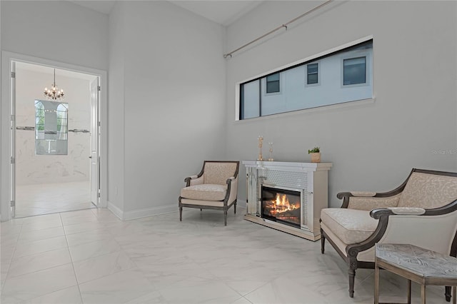 living area with a fireplace and an inviting chandelier