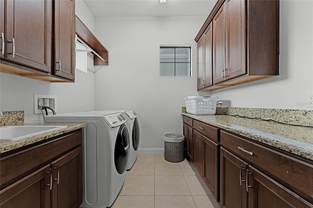 laundry room with cabinets, washer and dryer, sink, and light tile patterned floors