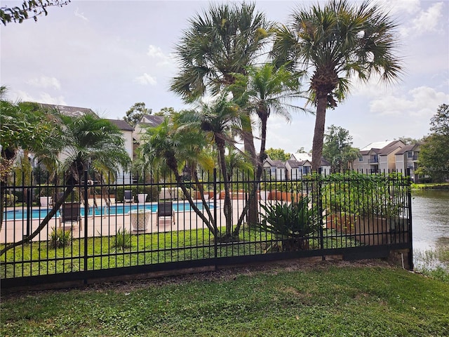 view of swimming pool with a lawn and a water view