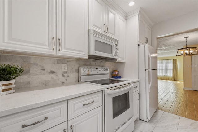 kitchen featuring hanging light fixtures, white cabinetry, light stone countertops, a notable chandelier, and white appliances