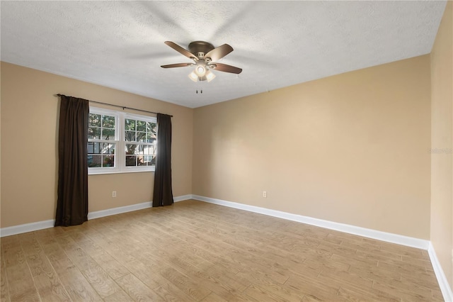 unfurnished room featuring a ceiling fan, baseboards, light wood-style flooring, and a textured ceiling