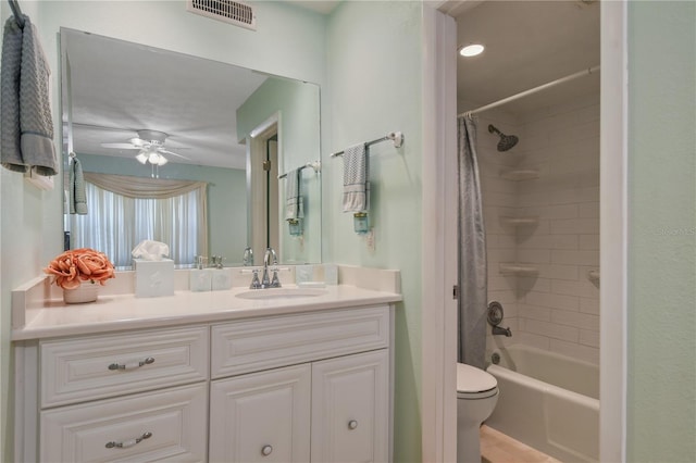 bathroom featuring toilet, shower / bath combo with shower curtain, vanity, visible vents, and ceiling fan