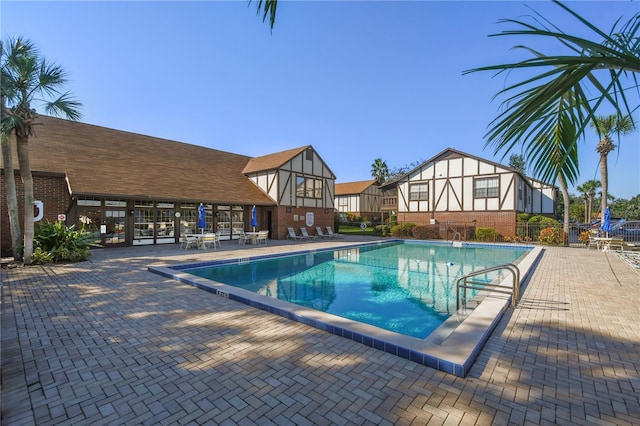 pool with a patio area and fence
