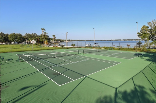 view of sport court featuring a water view, fence, and community basketball court