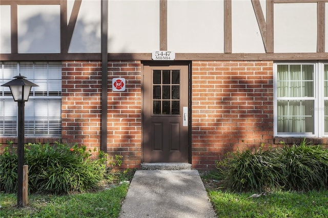 view of exterior entry with brick siding