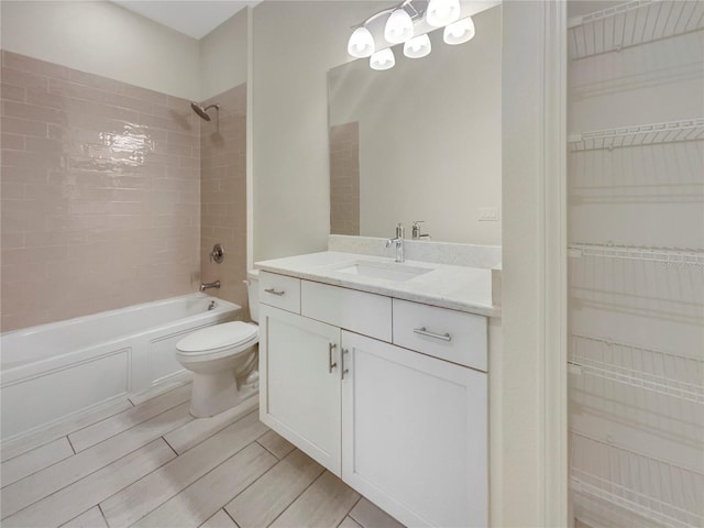 full bathroom with vanity, tiled shower / bath combo, and toilet