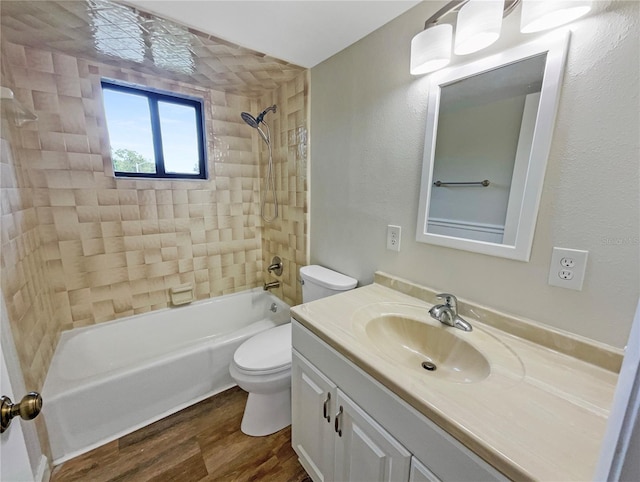 full bathroom with vanity, wood-type flooring, tiled shower / bath, and toilet