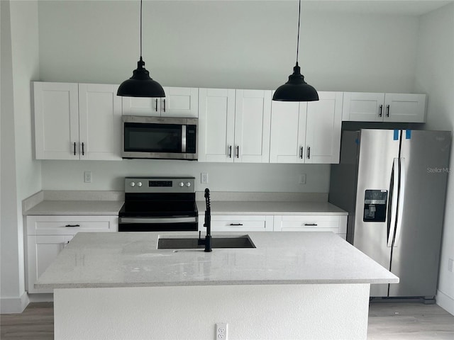 kitchen featuring light stone countertops, stainless steel appliances, sink, and white cabinets