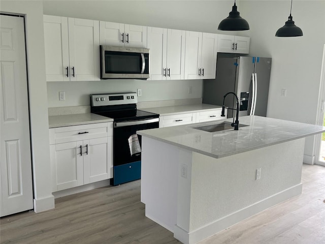 2572 SW 159th Ln, Ocala, FL 34473 - kitchen featuring appliances with stainless steel finishes, a sink, light wood-style floors, and white cabinetry