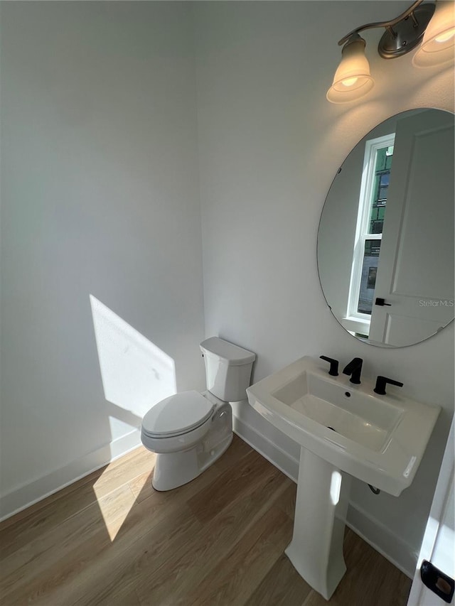 bathroom featuring hardwood / wood-style floors and toilet