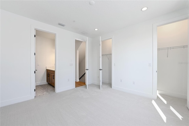 2110 Whitney Marsh Aly, Orlando, FL 32804 - unfurnished bedroom featuring light colored carpet, recessed lighting, baseboards, ensuite bath, and two closets