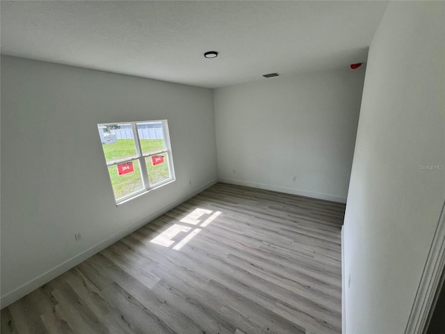 unfurnished room with light wood-type flooring