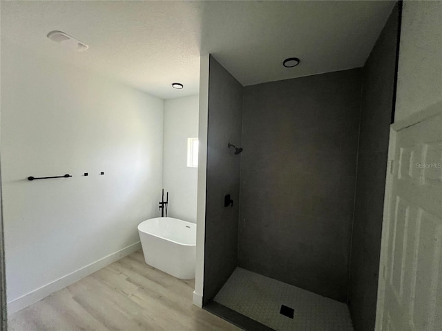 bathroom with shower with separate bathtub and hardwood / wood-style flooring