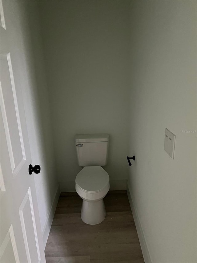 bathroom featuring wood-type flooring and toilet