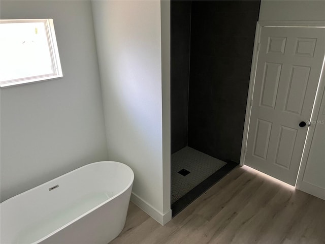 bathroom featuring shower with separate bathtub and hardwood / wood-style floors