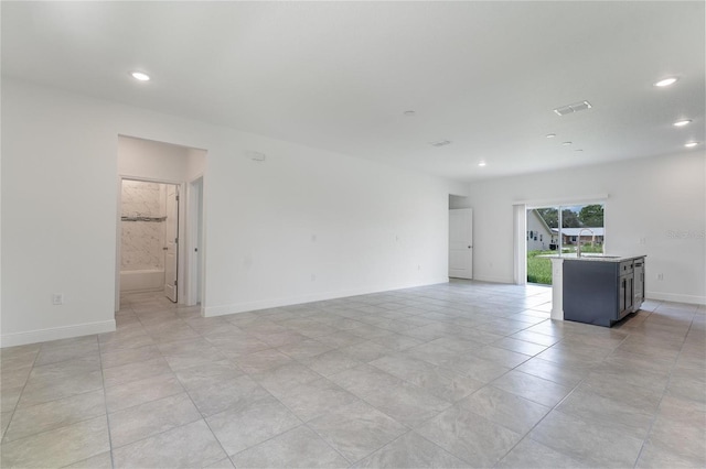 empty room featuring light tile patterned floors and sink