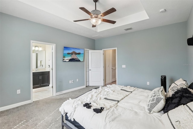 bedroom with ensuite bathroom, ceiling fan, light colored carpet, and sink