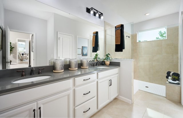 bathroom with vanity, tile patterned flooring, and a tile shower