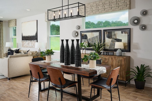 dining area featuring an inviting chandelier, light wood-type flooring, and a wealth of natural light