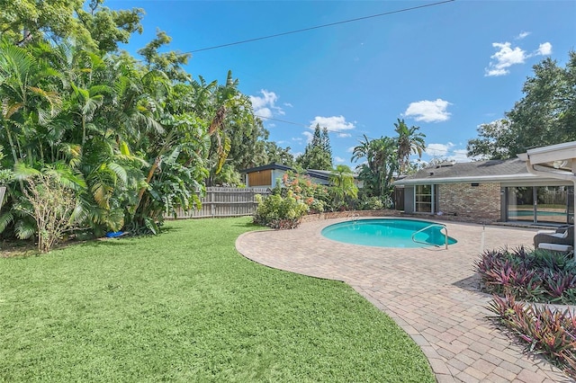 view of swimming pool featuring a yard and a patio