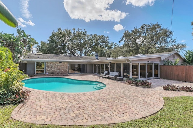 view of swimming pool featuring a patio area and a sunroom