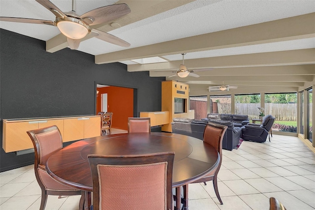 dining room with a textured ceiling, lofted ceiling with beams, and light tile patterned floors